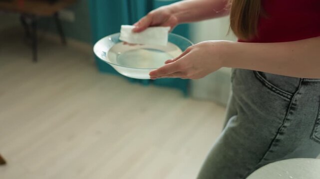 fever cooling method, cooling fabric used for fever relief, person lowers cloth onto skin to soothe high temperature, applying damp cloth to forehead to decrease fever and comfort patient