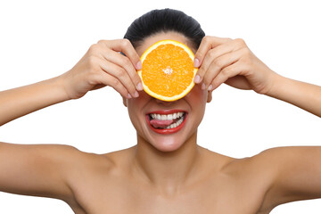 Woman holding orange slice over eyes licking lips