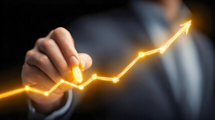 Businessperson drawing a glowing upward trend graph symbolizing growth and success in a digital and dynamic business environment with a dark background