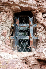 Secluded Sandstone Hermitage With Mosscovered Walls, Sunlit Ruin On Cliff With Iron Lattice And Moss