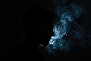 Silhouette of a person exhale smoke in dark. Mystery and darkness theme