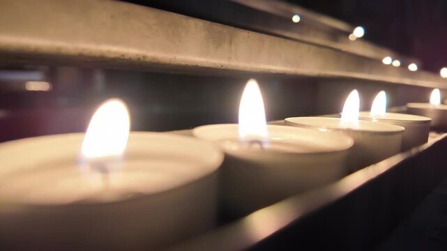 Row of Lit Candles in a Dark Church