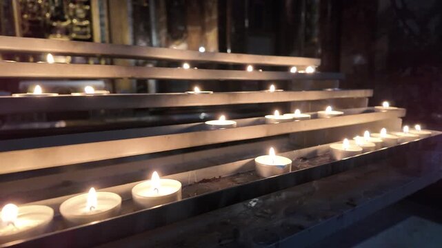 Burning prayer candles in a row inside a church, Slow Motion