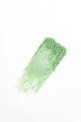 A sample eye shadow texture in a delicate green or mint tone on a white background. The top vertical view. A copy space. Shadow texture template