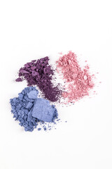Several multi-colored scattered eyeshadow on a white vertical background. bright examples of textures of decorative cosmetics. Beauty and fashion.