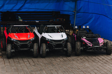 A photograph of many colorful children's plastic cars parked in a rental park.