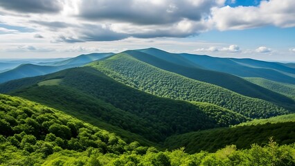 Rolling green hills and mountains under a cloudy blue sky on a sunny day in a natural landscape