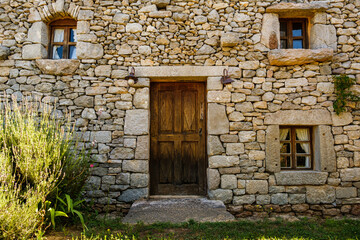Fototapeta premium A traditional stone structure with a weathered wooden door and small windows, typical of Croatian coastal architecture