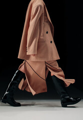 Fashion classy details of brown jacket, skirt and leather boots, fancy cloth on black background