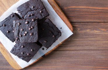Chocolate Brownies with Chocolate Chips on a Wooden Board