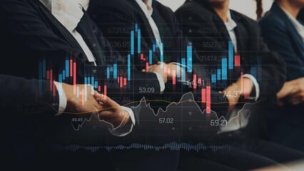 A group of business professionals engaged in a financial analysis, highlighted by a stock market graph overlay, showcasing teamwork in a modern office setting. Raster