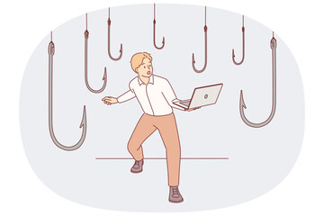 Trap hooks around man with laptop as metaphor for dangers of deception and scammers on internet