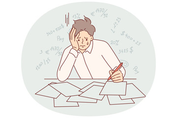 Bankrupt businessman is crying because of financial problems, sitting at table with tax documents