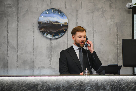 Hotel concierge talking on telephone at reception desk