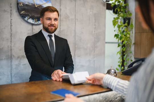 Hotel receptionist processing credit card payment at check in