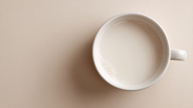 Top-down flat lay of milk in a white ceramic cup, realistic texture, clean neutral background for easy isolation