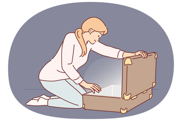 Woman opens large suitcase and sees glow, for concept of discovering treasure with valuables
