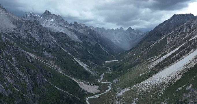 Aerial view of beautiful high altitude forest canyon and snow capped mountain landscape