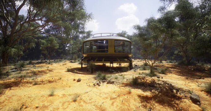 A unique circular structure stands in a dry, rugged environment surrounded by trees and sparse vegetation.