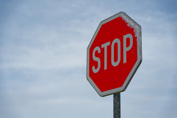 Obraz premium Red stop sign with snow in winter against blue sky symbolizing road safety