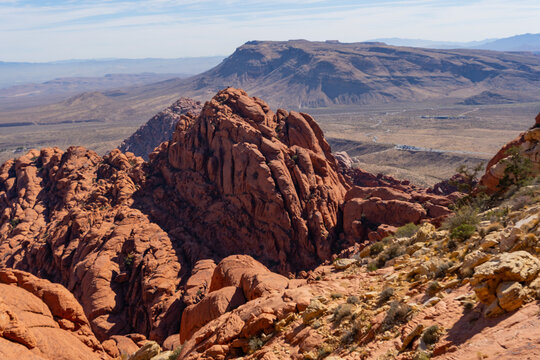 Vibrant red and white sandstone formations line the Calico Tanks Trail at Red Rock Canyon near Las Vegas. The moderate path winds through narrow canyons and rocky stairs, leading to a hidden natural w