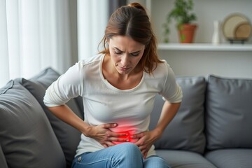 Obraz premium Woman on Sofa Experiencing Stomach Discomfort