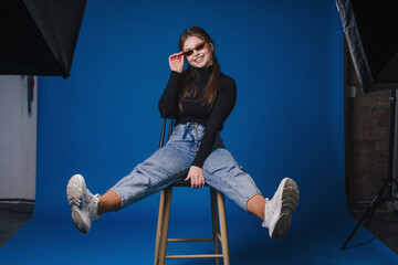 Dynamic female subject posing confidently with studio equipment nearby