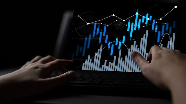 Person analyzing financial charts on a laptop screen, showcasing modern technology and investment insights in a dark setting for data analysis and decision-making. Scalp - Powered by Adobe