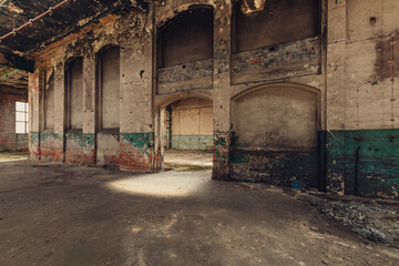 Abandoned Industrial Hall Interior with Decaying Walls and Arches