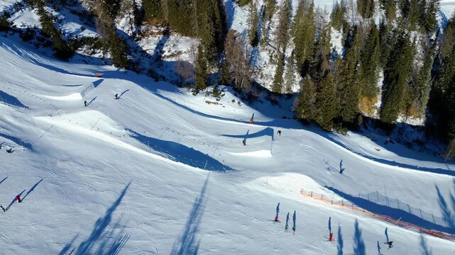 Skiers and snowboarders enjoy a vibrant winter day at an Austrian alpine resort Flachau . Sun-drenched slopes and fresh snow offer perfect conditions for winter sports enthusiasts.