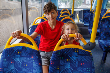 Two children passengers happily enjoying a bus ride in London
