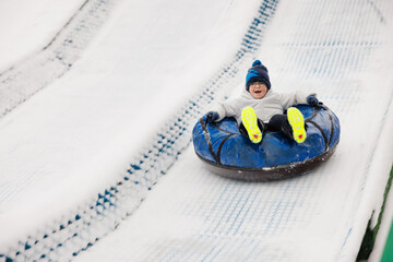 Child Enjoying Snow Tubing on a Winter Day