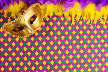 Top view of a beautiful composition of colorful masks, confetti, Mardi Gras decorations. Yellow Mardi Gras banner.