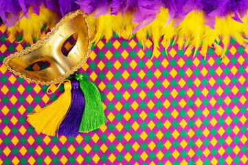 Top view of a beautiful composition of colorful masks, confetti, Mardi Gras decorations. Yellow Mardi Gras banner.