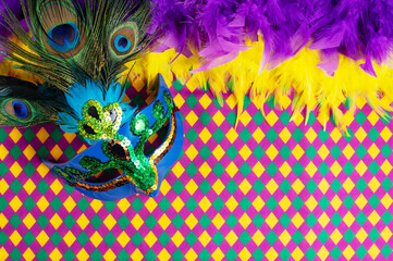 Top view of a beautiful composition of colorful masks, confetti, Mardi Gras decorations. Yellow Mardi Gras banner.