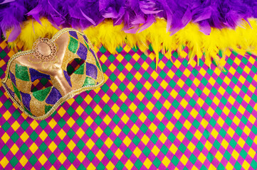 Top view of a beautiful composition of colorful masks, confetti, Mardi Gras decorations. Yellow Mardi Gras banner.