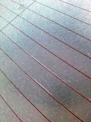 A close up view of white frost and ice crystals formed on a glass surface during a cold winter morning creating a beautiful natural pattern and abstract texture for backgrounds