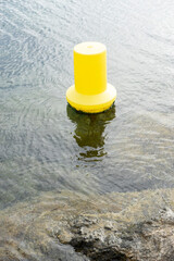 A yellow buoy floating in clear water.. Palma de Mallorca, Spain