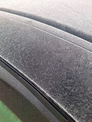 A thick layer of white frost and ice covering the top edge of a car door on a freezing winter morning showing the harsh weather conditions for vehicles parked outside in the cold