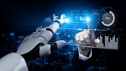 A close-up view of a human hand and a robotic hand interacting with digital data graphics, showcasing the integration of technology and human ingenuity in a modern workspace. Scalp