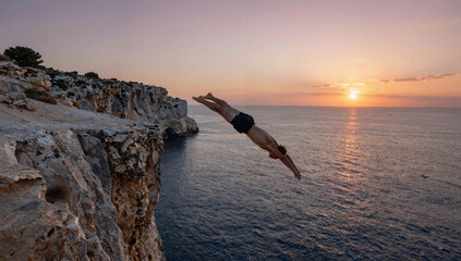 Daring cliff dive at sunset from a limestone cliff into the Mediterranean Sea