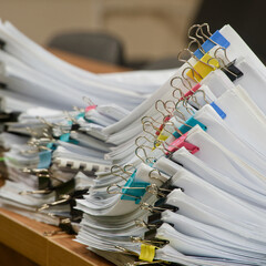Large stacks of paperwork and reports organized for review. Concept for archives, social benefits claims, or government administration. Photo