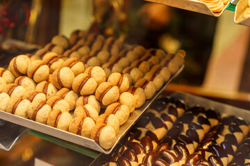 A display of cookies with different toppings, including chocolate chips and nuts The tray with nuts is at the bottom of the display