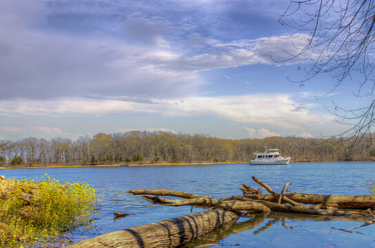 Boat Floating on the Nickell  Branch. A boat is cruising on a Lake Barkley under a bright blue sky with patches of clouds.