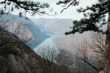 Wide view of Drina River flowing through canyon above Perucac Lake in Tara National Park, Serbia. Mountain terrain with forest slopes and calm water.