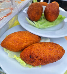A plate of traditional Turkish kibbeh also known as icli kofte served on a bed of fresh lettuce on a white plate in a restaurant for people who enjoy authentic middle eastern cuisine