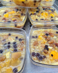 Traditional Turkish ashura or Noahs pudding made with grains and pulses and nuts served in plastic containers as a healthy and religious dessert for a cultural celebration meal