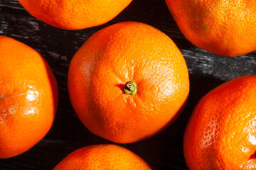 tangerine on black wood background top view