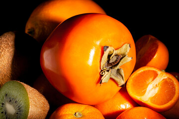 persimmon tropical fruit mix on black background