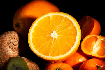 sliced orange tropical fruit mix on black background